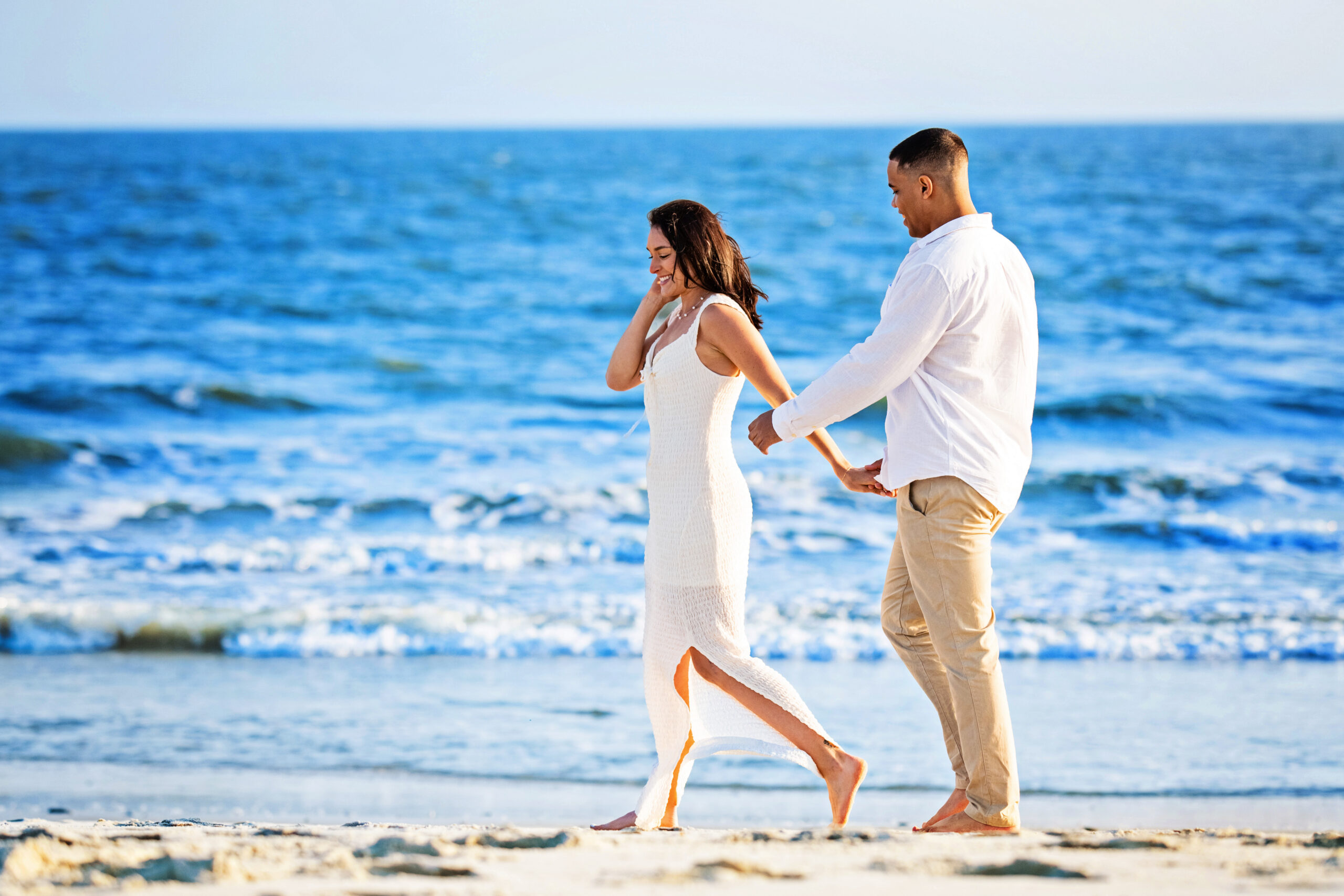 An engaged couple Engaged couple walking along the water